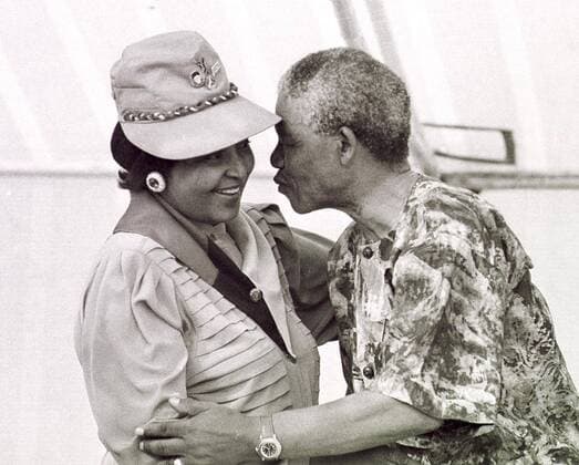 Nelson Mandela and Winnie Madikizela-Mandela CAPE TOWN, SOUTH AFRICA - March 1990: Nelson Mandela leans forward to kiss his wife Winnie Madikizela-Mandela at a rally held in Khayelitsh, in March 1990. ( Gallo999159