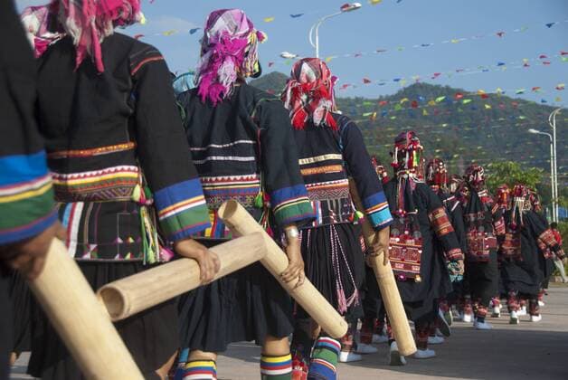 IMAGO Cultures of the world, Akha Volk in Laos Festival, ethnische Minderheit, Frauen vom Volk der Akha aus der Provinz Phongsali in Laos marschieren in bunter Tracht mit Bambusrohren, Jiangcheng, Stadt Pu er, Provinz Yunnan, Volksrepublik China, Südostasien, Asien iblsau01834609