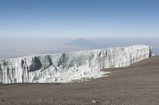  Schmelzendes Eis, abgebrochene Eiswand, Kersten Gletscher am Kraterrand des Kibo, Gipfel Uhuru Peak, erloschener Vulkan, hinten der Berg Mount Meru, Kilimandscharo Nationalpark, Marangu Route, Tansania, Ostafrika, Afrika ibxsau01838666