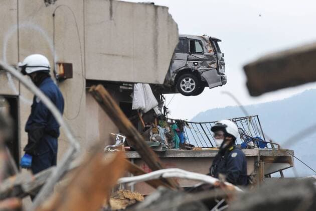 (110322) -- IWATE (JAPAN), March 22, 2011 (Xinhua) -- Rescuers work in quake-devastated Iwate Prefecture, Japan, on March 21, 2011. The tsunami disaster has actually inundated a large area behind the board. The National Police Agency said Tuesday that the catastrophic earthquake and ensuing tsunami have left 9,079 people dead and 12,645 others unaccounted for in Japan by 12:00 local time (0300 GMT). (Xinhua Huang Xiaoyong) (lr) JAPAN-IWATE-QUAKE-AFTERMATH 