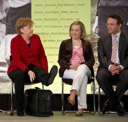 L-R: Bundeskanzlerin Angela MERKEL legt ihr linkes Bein auf einen Koffer, Bundesfamilienministerin Kristina SCHRÖDER , Bundesinnenminister Dr. Hans-Peter FRIEDRICH - Ausstellungseröffnung - Frauen schreiben Fußballgeschichte - die von der Stiftung DFB Fußballmuseum GmbH unterstützt wird. Vor der Frauen Fussball Weltmeisterschaft in Deutschland (26. Juni bis 17. Juli) empfängt Bundeskanzlerin Angela Merkel die Frauen-Nationalmannschaft im Bundeskanzleramt in Berlin, GER, Deutschland am 05.04.2011