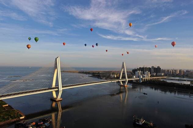 HAIKOU, CHINA - JUNE 15: (CHINA OUT) Hot Air Balloons fly over the Qiongzhou Strait during the 2011 Haikou Hot Air Balloon Festival on June 15, 2011 in Haikou, Hainan Province of China. The four-day 2011 Haikou Hot Air Balloon Festival as well as the H1 China Hot Air Balloon Challenge kicked off on June 12 in Haikou, capital city of south China s Hainan Province. A total of 30 hot balloon teams from all over China performed and attracted numerous visitors.  CFPAufmacher 418365325