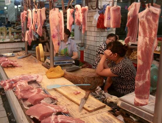 WUHAN, CHINA - JULY 05: (CHINA OUT) People sell pork at a market on July 5, 2011 in Wuhan, Hubei Province of China. China s consumer price index (CPI), a main gauge of inflation, is expected to rise as high as 6.2 percent, a three-year new high, in June. The inflation is driven by high raising food prices and living expenses.  CFP419016675