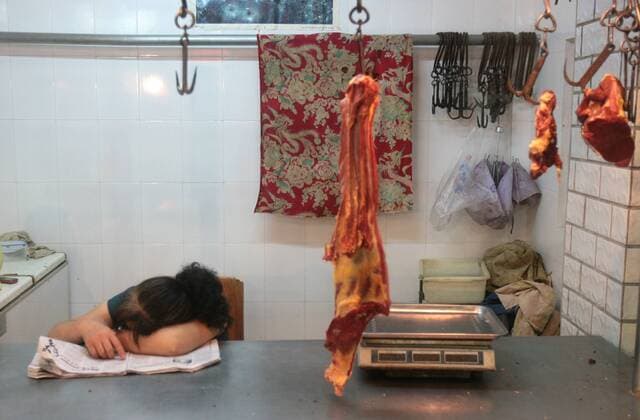 WUHAN, CHINA - JULY 05: (CHINA OUT) A seller sleeps as few people buy pork at a market on July 5, 2011 in Wuhan, Hubei Province of China. China s consumer price index (CPI), a main gauge of inflation, is expected to rise as high as 6.2 percent, a three-year new high, in June. The inflation is driven by high raising food prices and living expenses.  CFPAufmacher kurios Komik 419016676
