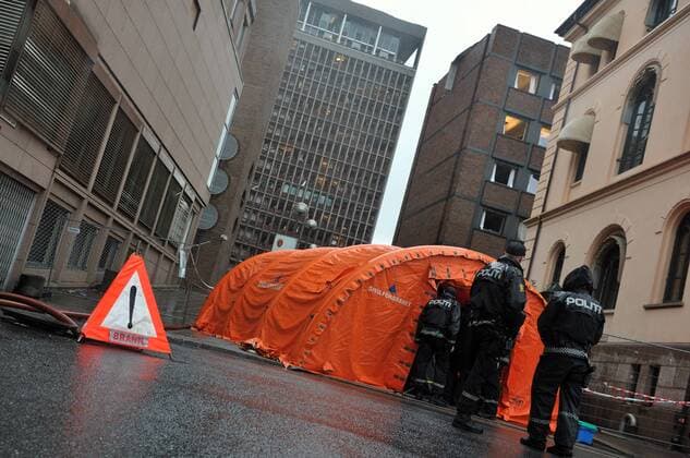 (110724) -- OSLO, July 24, 2011 (Xinhua) -- Policemen stand guard near the damaged government building in Oslo, capital of Norway, July 24, 2011. Norway has plunged in grief as its people come to terms with life after the massive bomb blast and shooting spree on Friday killed at least 93 people. (Xinhua Wang Qingqin) (zw) NORWAY-OSLO-GOVERNMENT BUILDING 