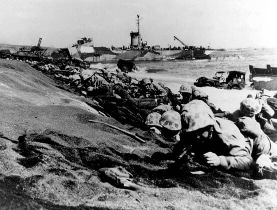 WW2: Fourth Marine Division moving up the beach of Iwo Jima on D-Day, 19th Feb. 1945. Making their fourth amphibious assault in 12 months, the veteran fighters are ready to secure the right flank of the initial beach head. An LSM is in the background. Mono Print !AUFNAHMEDATUM GESCHÄTZT! UnitedArchives0782774