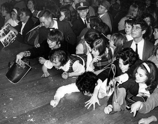 Washington : Beatles arrive in a snowstorm and the usual blizzard of publicity. Beatles fans at the Washington Coliseum, clamber for Jelly Babies which had been thrown on to the stage. February 1964 Mono Negative !AUFNAHMEDATUM GESCHÄTZT! UnitedArchives1199769