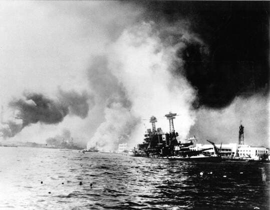 Struck by two torpedoes and two big bombs , the battleship California ( right ) settles to the bottom during a Japanese sneak attack on Pearl Harbour . Clouds of smork mark the graves of other ships sunk in the attack . Debris litters the water in the foreground . Naval installations can be seen in the right background . !AUFNAHMEDATUM GESCHÄTZT! Mono Print UnitedArchives1226802