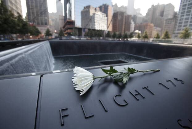 20 Jahre Anschläge vom 11. September: Gedenkkultur in den USA A single white flower is left on one of the panels containing the names of the victims of the attacks on the first day that the 9 11 Memorial was opened to the public at the World Trade Center site in New York, September 12, 2011.  WAX20110912320