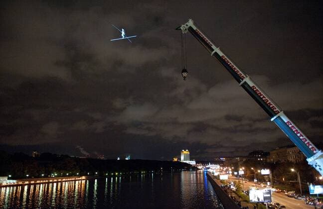 ITAR-TASS: MOSCOW, RUSSIA. SEPTEMBER 29, 2011. Swiss tightrope artist Freddy Nock (top) balances at a height of 30 metres during his unsuccessful attempt to walk across a tightrope over the Moskva River. Nock performed his stunt in central Moscow, near Gorky Park, on the eve of the 5th World Festival of Circus Art.  RE0EF27A