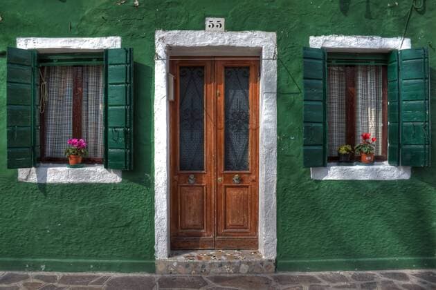 Tür und zwei Fenster mit Fensterläden auf Burano bei Venedig, Italien