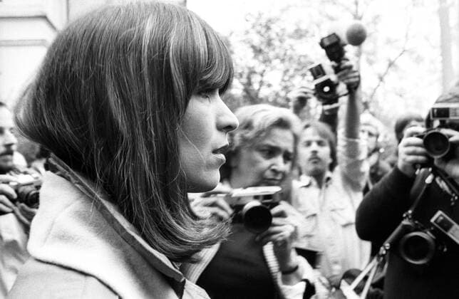Marianne Bachmeier 11 82 hör Der Prozess Marianne Bachmeier am 2. November 1982 Frau deutsch Deutsche Mutter Mörderin Mord Kriminalfall Fall Kriminalität kriminell Verbrechen Verbrecherin tötete im Gerichtssaal Saal Gericht den mutmaßlichen Mörder ihrer Tochter Anna Bachmeier Klaus Grabowski erschoss ihn erschießen Schuss mehrere Schüsse in den Rücken Pistole Waffe Rache Rächerin Racheakt Selbstjustiz Verurteilung verurteil 1996 an Krebs gestorben dunkelhaarig langhaarig schulterlang Pony leger Mantel Schal Menschen Menschenmasse Fotografen Journalisten Schaulustige Medien Medienereignis ernst seitlich von der Seite Querformat quer Portrait halb sw