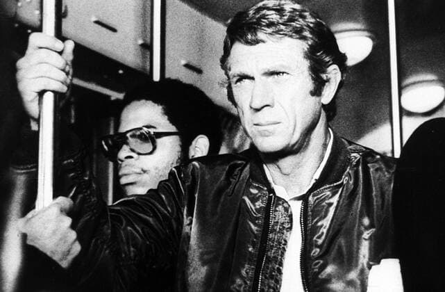 Steve McQueen (Schauspieler) 05 82 teu Steve McQueen in einer Szene aus dem Film Cincinnati Kid (1965) Kino Kinofilm Film Schauspiel US-Amerikaner US-Amerika Amerika Mann stehen stehend halten haltend Stange ernst leger Jacke kurzhaarig Querformat quer halb sw