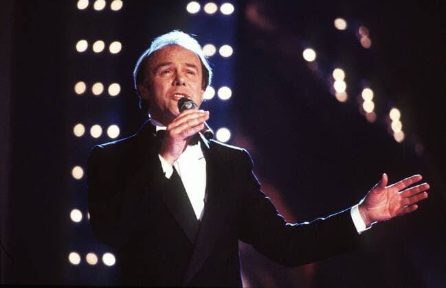 Michael Heltau 12 85 vZ Mann Musik Gesang Schlager dunkelhaarig seriös quer halb Auftritt singend Mikrophon Hand
