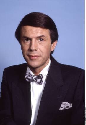 Salvatore Adamo (Sänger) 10 85 rag Salvatore Adamo bei einem Fototermin am Rande der TV-Aufzeichnung Melodien für Millionen am 12. Oktober 1985 Mann Italien Italiener italienisch Sizilien Sizilianer Musik Gesang deutsche Schlager Schlagersänger Schlagerstar dunkelhaarig schwarze Haare kurzhaarig Seitenscheitel seriös festlich feierlich Anzug Jackett schwarz weißes Hemd weiß Fliege Silber grau sitzen sitzend neutral lächeln lächelnd Hochformat hoch Portrait halb