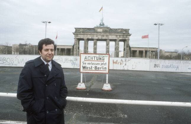 Conrad Schumann (Ex-DDR-Volkspolizist) 03 86 ru Ex-DDR-Volkspolizist Conrad Schumann im März 1986 am Brandenburger Tor Deutschland deutsch Deutscher Deutsche Mann Männer Einheit deutsche DDR Deutsche Demokratische Republik Hauptstadt geteilt geteilte Stadt Ostberlin Berlin Ost Sozialismus VoPo Mauerflüchtling Flüchtling Soldat Polizist ehemalig ehemaliger geflüchtet Foto historisch historisches Kalter Krieg Mauerbau Flucht am 15. August 1961 german former gdr policeman wall germany quer halb stehend draußen lächelnd exklusiv exklusiver Fototermin