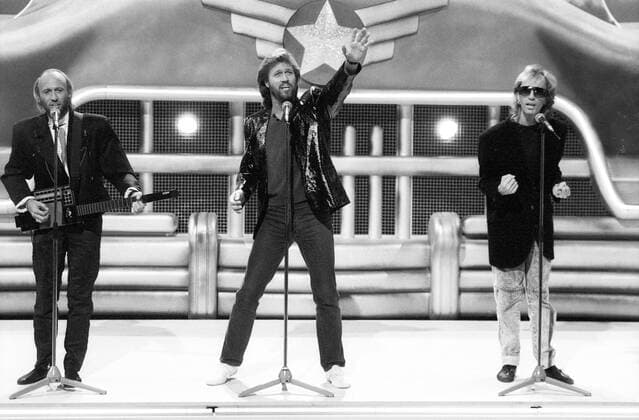 Bee Gees (Popgruppe) 09 87 ru v.li.: Maurice, Barry und Robin Gibb im März 1989 bei einem Auftritt der Bee Gees in Wetten, dass..? (ZDF) aus Hof Mann Männer Musiker Gesang Mann Gesang Pop Popmusik Bee Gees Band Gruppe musician singer musicians quer ganz stehend singend gestikulierend Bühne live sw