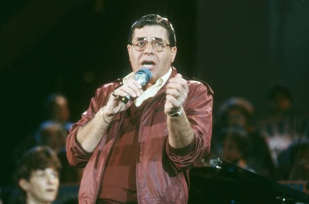Jerry Lewis 05 87 rag Schauspiel Film Komik USA Mann dunkelhaarig Brille leger Jacke quer halb stehend Auftritt Mikrophon haltend gestikulierend sprechend