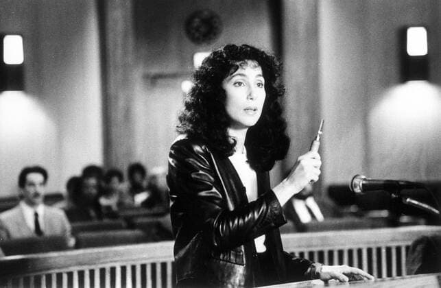 Cher (Schauspielerin) 3 88 - Cher in einer Filmszene aus Suspect - Unter Verdacht Frau US-Amerikanerin Sängerin Regisseurin Oscarpreisträgerin Broadway-Darstellerin stehen stehend Tisch langhaarig schwarzhaarig leger Lederjacke Gestik gestikulieren gestikulierend Hand Stift halten haltend Gerichtsaal Querformat quer Portrait halb sw