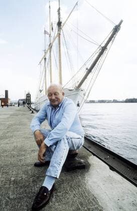 James Krüss 04 88 hör Mann Autor Schriftstellerei grauhaarig Halbglatze leger Jacke Hemd blau Jeans hoch ganz sitzend draußen Schiff Fluß neutral
