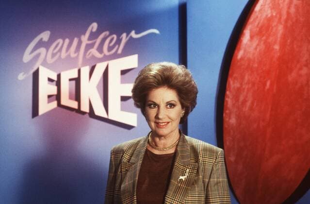 Johanna von Koczian in Fragen Sie Frau Dr. Cora 02 89 dar Frau Schauspielerin Schauspiel Theater TV Fernsehen Film dunkelhaarig kurzhaarig seriös Blazer Schmuck Kette Brosche Ohrringe halb quer stehend lächelnd Fernsehstudio Kulisse Dekoration Seufzer-Ecke Logo