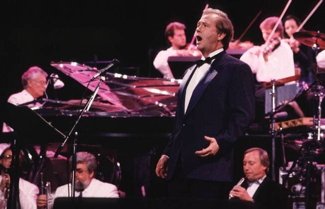Rene Kollo (vorne) (Sänger, Intendant) 11 89 hof Mann Gesang Klassik Oper Operette Intendanz kurzhaarig seriös Hemd Jackett Fliege gestikulierend singend Bühne Auftritt Konzert Instrument halb quer