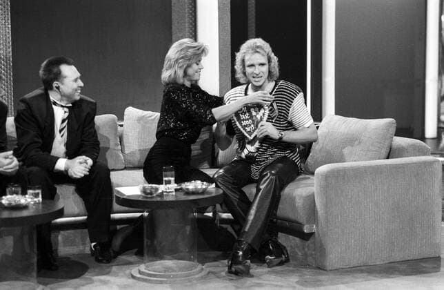 Jane Fonda mit Slava Zaitsev und Thomas Gottschalk (re.) 09 89 ru Jane Fonda, Slava Zaitsev und Thomas Gottschalk (re.) am 30. September 1989 in Wetten, dass...? (ZDF) aus Oldenburg Amerika Amerikanerin USA amerikanische Schauspiel Schauspielerin Frau Film Kino Oscarpreisträgerin Oscar TV Fernsehen Show langhaarig blond Bluse Sofa Couch elegant Tisch Glas Wasserglas sitzend umhängend Russland Russe russischer Mann Mode Modeschöpfer Designer Modedesigner Modemacher Saizew Deutschland deutsch Deutscher Moderator Moderation Lebkuchenherz Herz Lebkuchen Du bist so süß leger lächelnd Lächeln sprechend redend Locken lockig lockige quer ganz sw