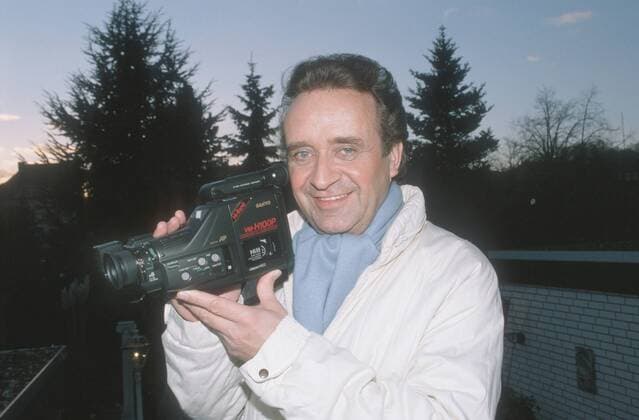 Günter Wewel (Sänger, Moderator) 02 90 hör Günter Wewel im Februar 1990 Deutschland deutsch Deutscher Mann TV Fernsehen Moderation Volksmusik Musik Operette Oper Bass Schlager german singer presenter host quer halb Portrait Videokamera Kamera Video Privatfilmer Filmer Hobby Filmen draußen stehend exklusiv privat Homestory