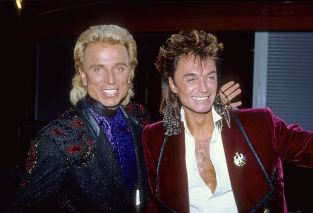 Siegfried & Roy 06 91 nou quer halb stehend lächelnd leger Mann langhaarig Show Magie Entertainment Zauber