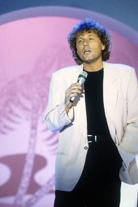 Bernhard Brink 06 91 nou hoch halb singend Auftritt Mikrophon seriös Sakko rosa Hosentasche Mann Musik Schlager Gesang blond Locken