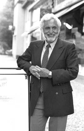 Carl Djerassi (Wissenschaftler) 05 91 Pop Carl Djerassi im Mai 1991 Mann Autor Wissenschaft Pille Anti Baby Verhütung Antibabypille Verhütungsmittel Erfinder Vater scientist author writer grauhaarig weißhaarig Bart seriös Krawatte Sakko Jackett draußen halb stehend angelehnt anlehnend lächelnd sw