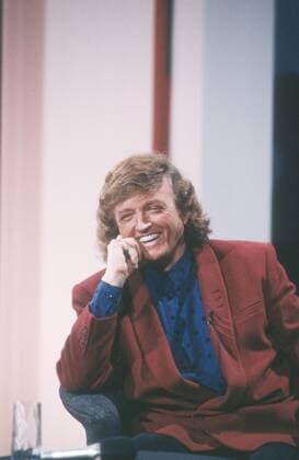 Frank Farian (Komponist, Produzent) 01 91 he Mann Musik Produktion Komposition Schlager Pop dunkelhaarig langhaarig Locken seriös Hemd Sakko sitzend halb hoch lächelnd aufgestützt TV-Studio