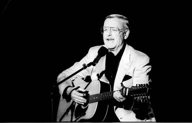 Roger Whittaker (Sänger) 11 90 Roger Whittaker in ARD-Wunschkonzert im November 1990 Mann Brite britisch Musik Lied Lieder deutsche Schlager Schlagersänger Liedermacher Kunstpfeifer Pfeifer Gesang Schlagerstar kurzhaarig kurze Haare Seitenscheitel Schnäuzer Schnauzbart Bart Oberlippenbart Brille Brillenträger seriös festlich feierlich Anzug Jackett Hemd sitzen sitzend lächeln lächelnd singen singend Auftritt auftreten auftretend Mikrofon Mikrofonständer Gitarre spielen spielend Fernsehen Fernsehsendung Sendung TV TV-Show Show Fernsehauftritt Fernsehstudio Studio Hochformat hoch Portrait halb sw