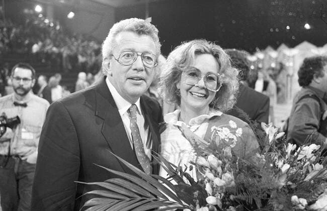 Dieter Thomas Heck mit seiner Ehefrau Ragnhild 11 90 - Dieter Thomas Heck mit seiner Ehefrau Ragnhild im November 1990 in Flitterabend (ARD) Mann Deutschland deutsch Deutscher Moderator Moderation Sänger Gesang Schlager Musik grauhaarig kurzhaarig Hemd Sakko Krawatte Brille seriös Frau langhaarig Blumen Blumenstrauß Gameshow Show Kulisse Studio Fernsehstudio TV Fernsehen Querformat quer halb stehend lächelnd Lächeln sw