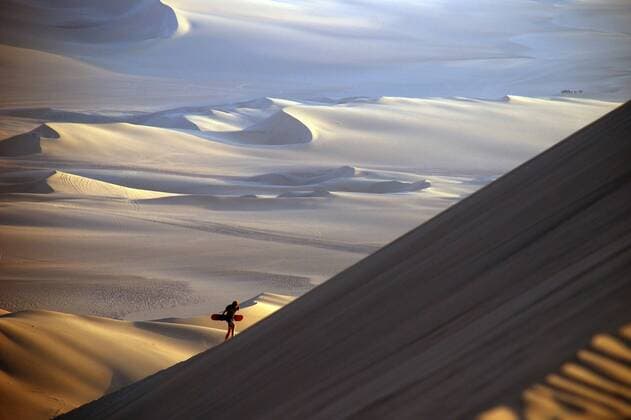  Sandboarder mit Sandboard läuft gewaltige Düne hinauf, Atacama Wüste, Oase Huacachina bei Ica, Peru, Südamerika iblmea02091798