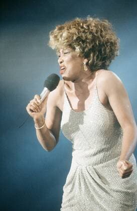 Tina Turner (Sängerin) 11 91 pp Frau Musik Pop Gesang USA dunkelhäutig dunkelhaarig kurzhaarig Locken sexy leger Minikleid gold Mikrophon haltend tanzend Auftritt Schmuck Ohrring singend gestikulierend halb hoch