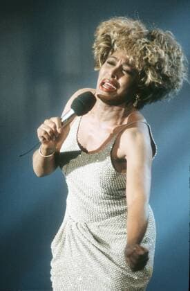 Tina Turner (Sängerin) 11 91 pp Frau Musik Pop Gesang USA dunkelhäutig dunkelhaarig kurzhaarig Locken sexy leger Minikleid gold Mikrophon haltend tanzend Auftritt Schmuck Ohrring singend gestikulierend halb hoch