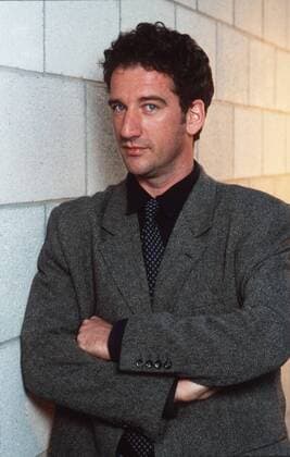 Heio von Stetten (Schauspieler) 04 97 her Mann TV fernsehen SCHAUSPIEL Film dunkelhaarig Locken seriös Hemd schwarz Jackett Krawatte stehend Wand Mauer angelehnt halb hoch Arme neutral