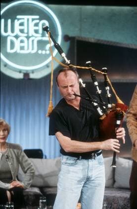 Wetten, daß...? (ZDF) mit Phil Collins 12 96 her TV Fernsehen Show Studio Dekoration Kulisse Mann dunkelhaarig leger Halbglatze Musik Pop Gesang Imstrument Dudelsack spielend Logo halb hoch 08.12.96 in Hannover