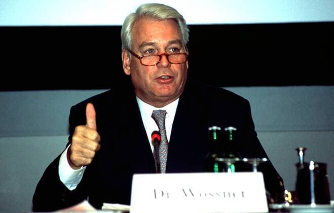 Dr. Mark Wössner (Medienmanager) 09 97 thg Mann Unternehmen Wirtschaft Management Medien Bertelsmann Pressekonferenz PK WEIßHAARIG seriös Hemd Jackett Krawatte sitzend Tisch Mikrophon Schild halb quer Brille sprechend gestikulierend
