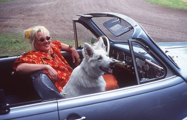 Gaby Köster und Hündin Frau Doktor im BMW V 8 in Auto Motor und Sport TV (VOX) 06 97 böw Frau TV Fernsehen Kabarett ENTERTAINMENT Komik blond langhaarig Hochsteckfrisur leger Bluse Rock orange draußen Auto sitzend Haustier Tier Hund Garten halb quer Sonnenbrille lächelnd Cabriolet Bj. 1955