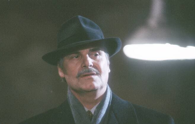 Peter Simonischek im Theaterstück Speer 01 98 te Mann Schauspiel Theater Auftritt Bühne Schnäuzer Hut Verkleidung Mantel stehend Lampe Schal Szene Portrait quer sprechend