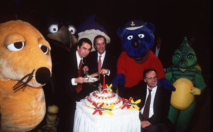 Der Kinderkanal - 1 Jahr-Jubiläumsfeier - 01 98 te TV Fernsehen Medien Kindersendung ZDF Jubiläum Feier Torte Figur Plüschtier Käpt n Blaubär Maus Rabe Rudi v.li.: Albert Schäfer Dieter Stolte Udo Reiter Torte Tabaluga halb quer