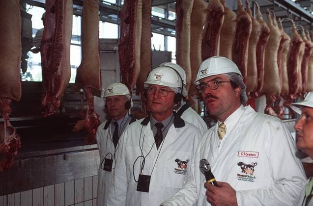 Clemens Tönnies (Mikrophon) mit Jochen Borchert (Mi.) bei Tönnies Fleisch 05 98 thg Unternehmen Lebensmittel Fleisch Schlachtung Wurst Mann draußen stehend Haus Gebäude Firma Helm Kittel weiß Fleisch halb quer Gespräch