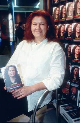Jutta Ditfurth (Politikerin) 10 00 puch Frau Politik Autor Journalismus Schriftstellerei Literatur Buch Titel Schild Das waren die Grünen. Abschied von einer Hoffnung dunkelhaarig langhaarig dunkle lange Haare leger Bluse weiss weiß sitzend aufstützend haltend Regal Bücherregal lächelnd halb hoch Fototermin am 18.10.2000 in Frankfurt a.M. Frankfurter Buchmesse 2000