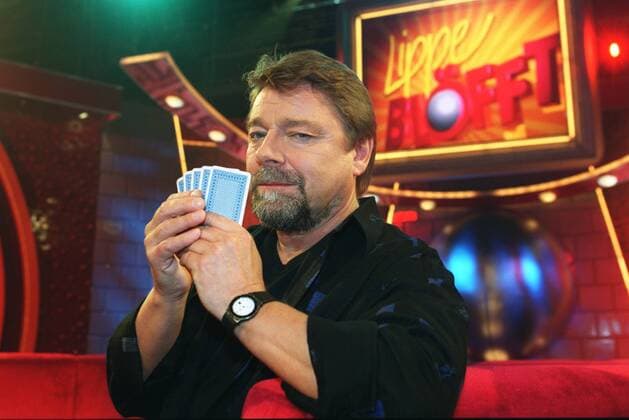Jürgen von der Lippe in Lippe blöfft (ARD) 02 04 pp Mann Moderator Moderation TV Fernsehen Kabarett Komik Comedy Show Unterhaltung Sendung WDR dunkelhaarig kurzhaarig Bart Schnäuzer leger T-Shirt Hemd halb quer stehend Studio Kulisse Dekoration lächelnd Gestik gestikulierend Hände Karten spielend Kartenspiel pokernd Poker Poker-Face Pokerface blöffend Mimik Logo haltend Fototermin am 05.02.2004 in Köln