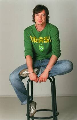 Nils Brunkhorst (Schauspieler) 05 03 her Mann TV Fernsehen Schauspiel Schauspieler dunkelhaarig kurzhaarig leger Pulli Pullover Shirt Brasil Jeans Turnschuhe ganz hoch sitzend Barhocker Hocker lächelnd Studio Freisteller freistellbar Fototermin 2.000 Folgen Verbotene Liebe (ARD) am 06.05.2003 in Hamburg