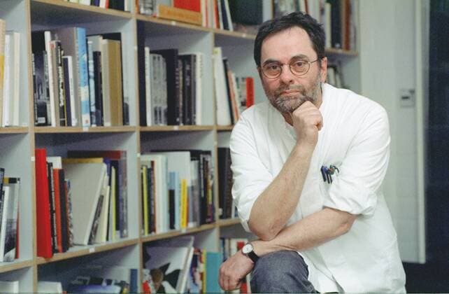 Gerhard Steidl (Verleger) 12 04 thg Mann Medien Verlag Verleger Autor Literatur Schriftstellerei kurzhaarig dunkelhaarig Brille Bart leger Hemd halb quer lächelnd stehend aufgestützt Büro Bücher Regal Bücherregal Fototermin am 20.12.2004 in Göttingen (exklusiv)