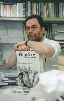Gerhard Steidl (Verleger) 12 04 thg Mann Medien Verlag Verleger Autor Literatur Schriftstellerei kurzhaarig dunkelhaarig Brille Bart leger Hemd halb hoch sitzend lächelnd aufgestützt Büro Bücher Regal Bücherregal Buch von Günter Grass Fünf Jahrzehnte - Ein Werkstattbericht haltend aufgestützt Fototermin am 20.12.2004 in Göttingen (exklusiv)