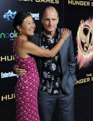 Actor Woody Harrelson, a cast member in the motion picture sci-fi thriller The Hunger Games , attends the premiere of the film with his wife Laura Louie at Nokia Theatre in Los Angeles on March 12, 2012.  LAP2012031233